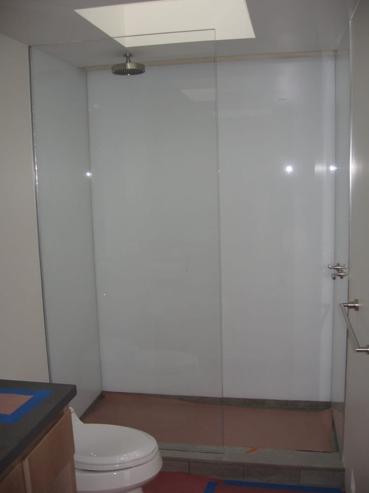 A bathroom with a shower area and separate bathing area